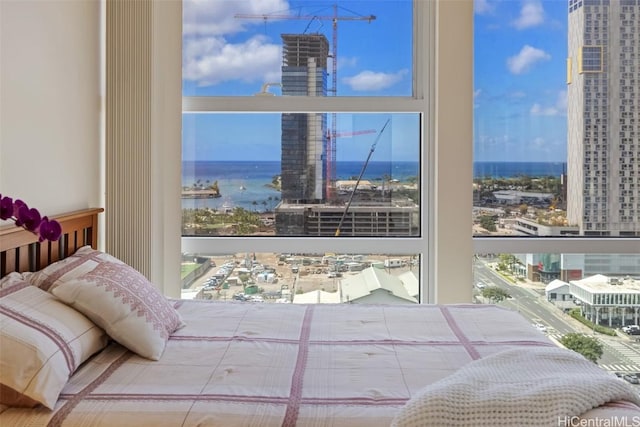 bedroom featuring a city view and a water view