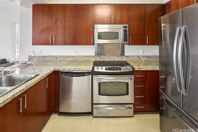 kitchen featuring a sink, light stone countertops, appliances with stainless steel finishes, and light tile patterned flooring