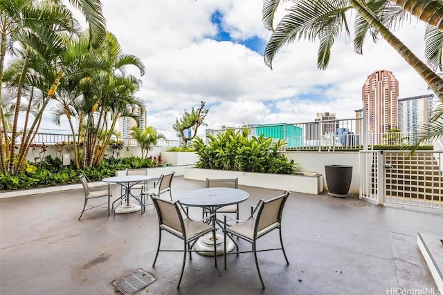 view of patio / terrace with a city view, outdoor dining area, and visible vents