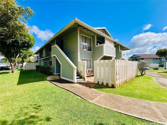 rear view of property featuring a lawn