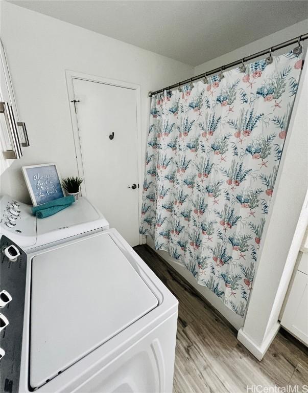 clothes washing area with washer and dryer, laundry area, and light wood finished floors