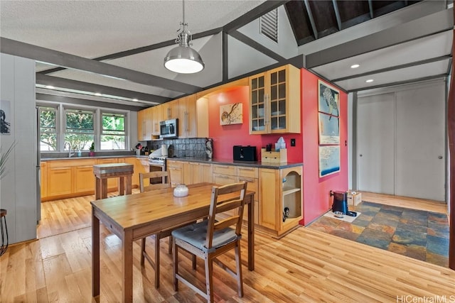 dining room with beamed ceiling, light wood-style floors, visible vents, and a textured ceiling