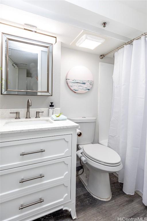 full bath featuring toilet, wood finished floors, and vanity