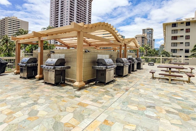 view of patio featuring a city view, a pergola, and a grill