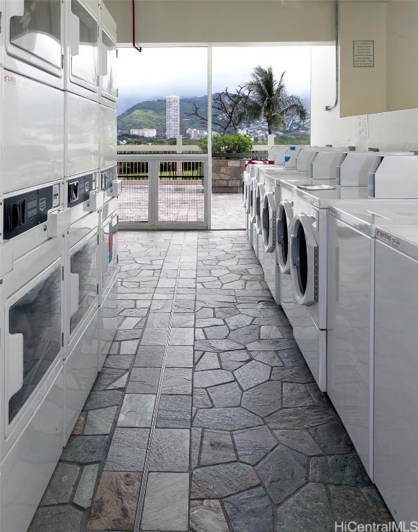 laundry area with community laundry area, independent washer and dryer, brick floor, and stacked washer and dryer