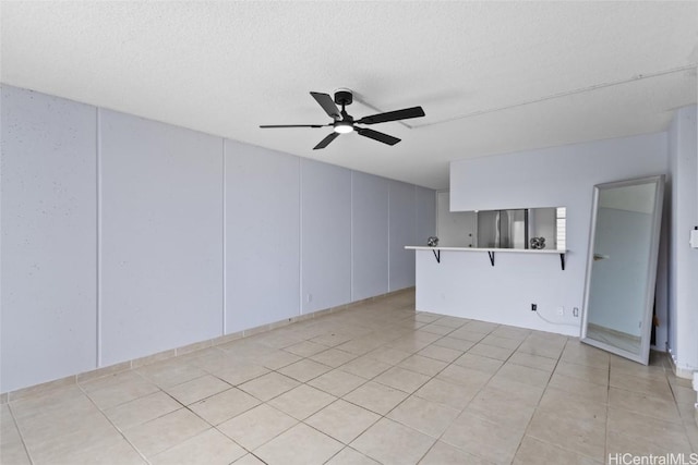 unfurnished living room featuring a textured ceiling, light tile patterned flooring, and ceiling fan