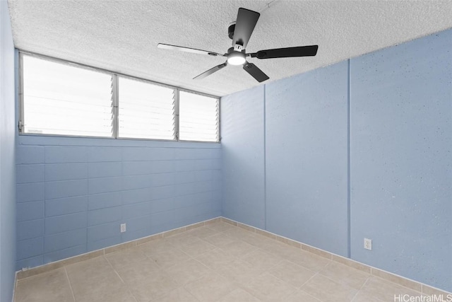 spare room with a textured ceiling and a ceiling fan