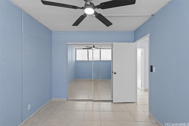 unfurnished bedroom featuring tile patterned floors, a textured ceiling, and ceiling fan