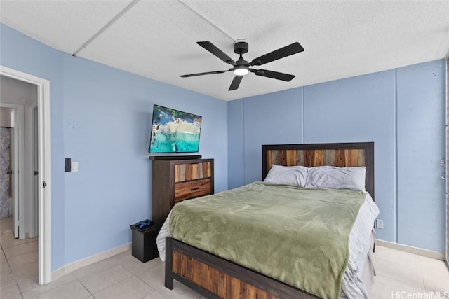 bedroom featuring light tile patterned floors, baseboards, a textured ceiling, and ceiling fan