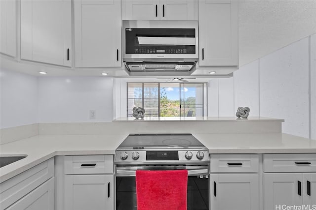 kitchen with white cabinets, stainless steel appliances, and light countertops