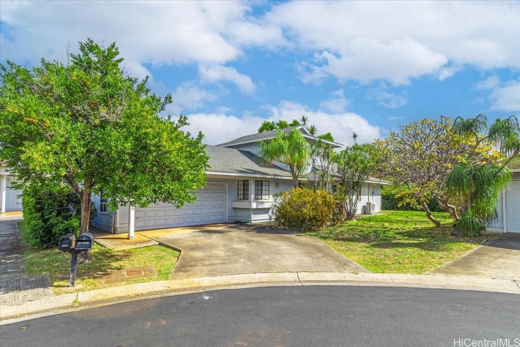 view of front of house with a front lawn, an attached garage, and driveway