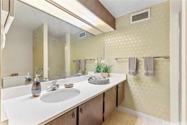 bathroom featuring vanity, baseboards, visible vents, and a stall shower