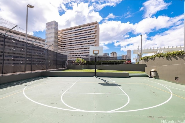 view of sport court featuring a city view, community basketball court, and fence