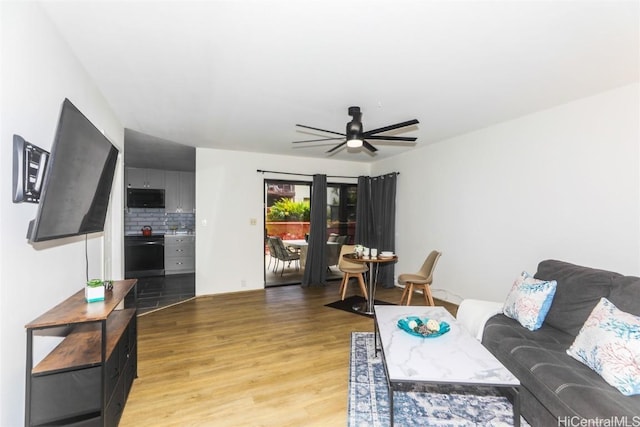 living area featuring light wood-style floors and ceiling fan