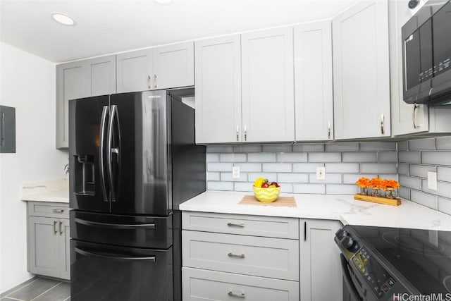 kitchen featuring electric panel, recessed lighting, gray cabinets, black appliances, and backsplash