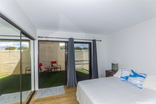 bedroom featuring access to exterior and light wood finished floors