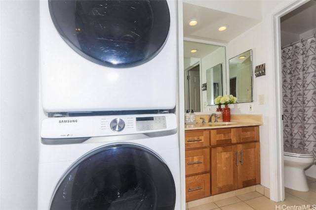 laundry room featuring stacked washer and dryer, a sink, recessed lighting, light tile patterned floors, and laundry area