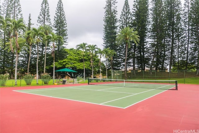 view of tennis court with community basketball court and fence