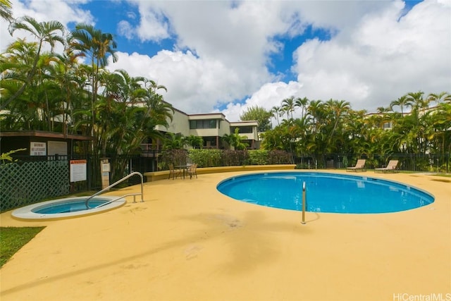 community pool featuring a community hot tub, a patio, and fence