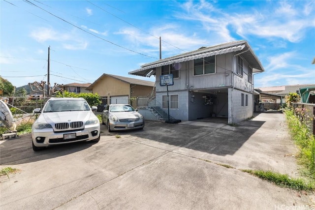 view of front of home featuring concrete block siding and fence