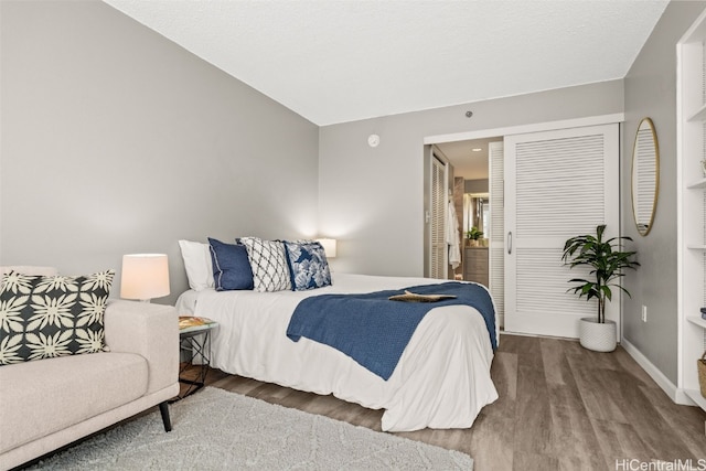 bedroom featuring a closet, baseboards, and wood finished floors