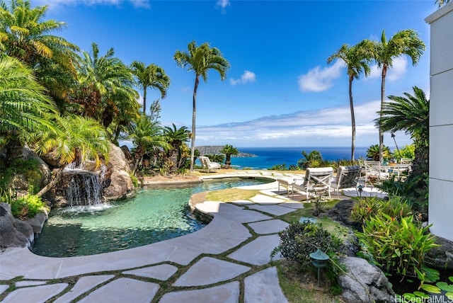 outdoor pool featuring a patio area, a jacuzzi, and a water view