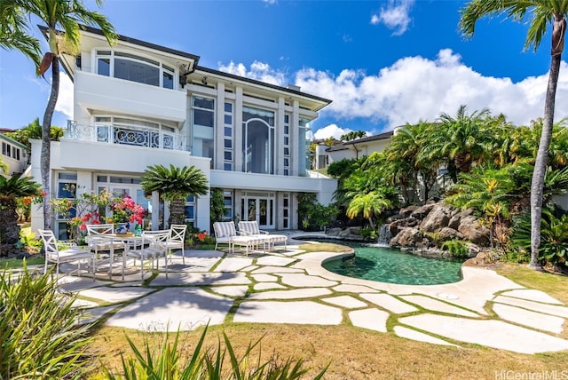 back of house with an outdoor pool, stucco siding, and a patio area