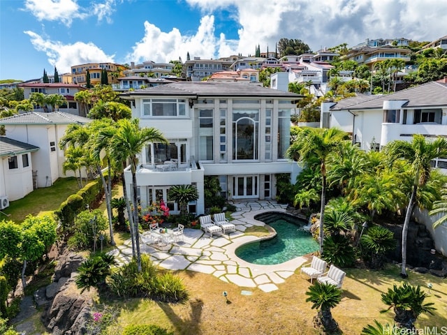 back of house with a patio, a balcony, an outdoor pool, french doors, and a residential view