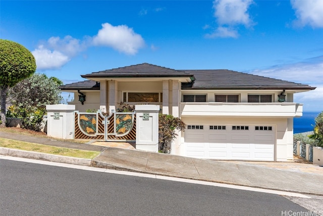 prairie-style house with stucco siding, an attached garage, and driveway