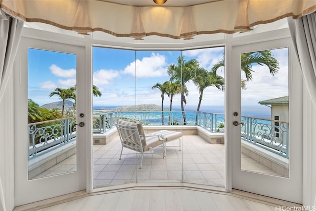 sunroom / solarium featuring french doors and a water view