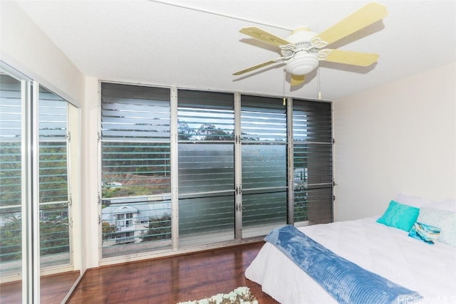 bedroom with multiple windows, wood finished floors, and a ceiling fan