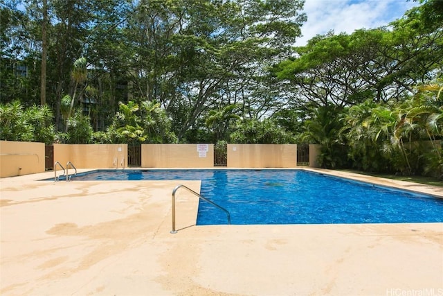 pool with a patio area and fence