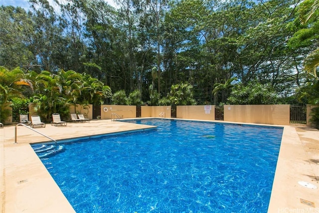 view of pool with a patio area and fence