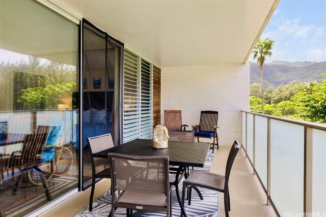 balcony with outdoor dining space and a mountain view