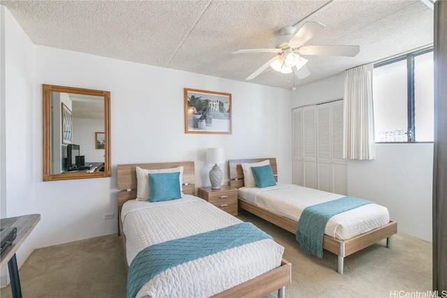 bedroom with a closet, carpet flooring, a textured ceiling, and a ceiling fan