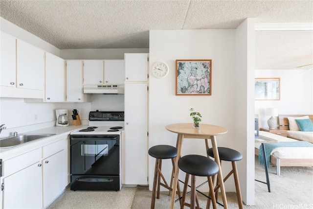 kitchen with under cabinet range hood, white cabinetry, range with electric cooktop, and a sink