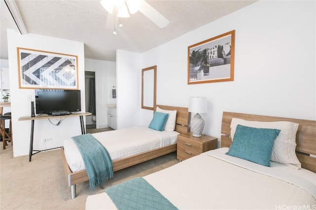 carpeted bedroom featuring ceiling fan, connected bathroom, and a textured ceiling