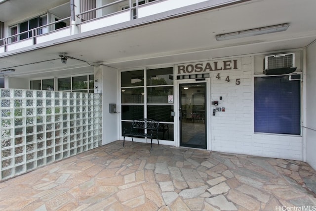 view of patio featuring a wall mounted air conditioner and a balcony