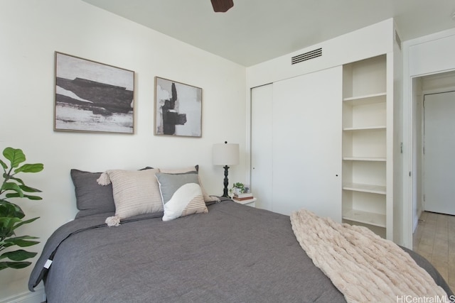 bedroom featuring a closet, visible vents, a ceiling fan, and wood finished floors