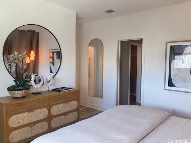 bedroom featuring visible vents and wood finished floors