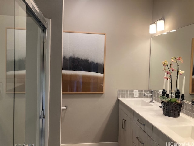 full bath featuring double vanity, an enclosed shower, backsplash, and a sink