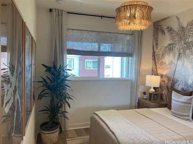 bedroom with a chandelier and wood finished floors