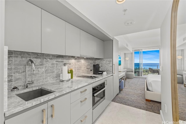 383 Kalaimoku St Unit E2006, Honolulu, HI 96815 - kitchen with a sink, stainless steel oven, tasteful backsplash, and light stone countertops