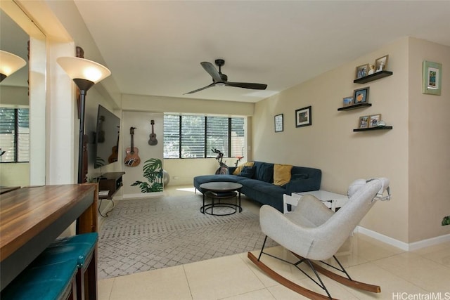 living area featuring tile patterned floors, baseboards, and ceiling fan