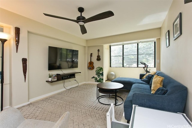 carpeted living area with baseboards and a ceiling fan