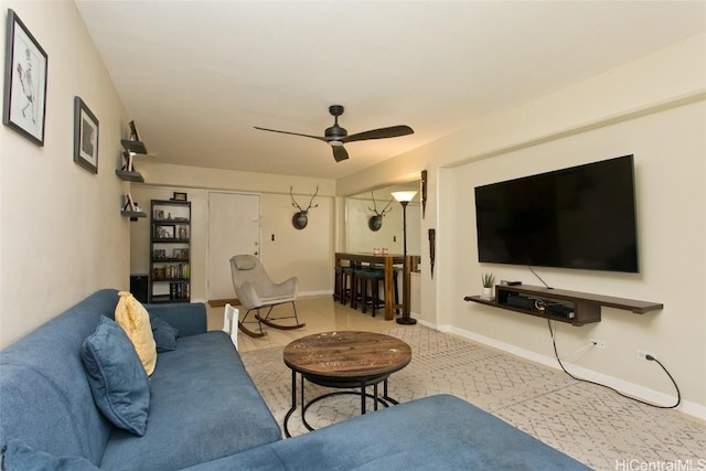 living room featuring a ceiling fan and baseboards