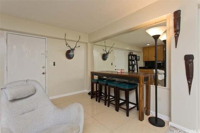 dining space featuring light tile patterned floors and baseboards