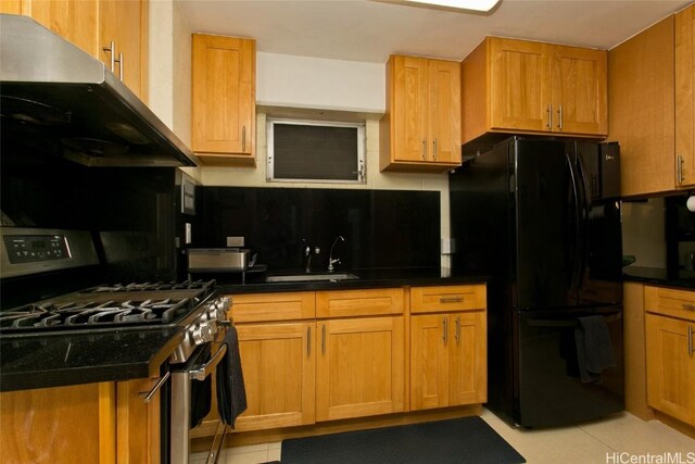 kitchen with a sink, range hood, freestanding refrigerator, gas stove, and decorative backsplash