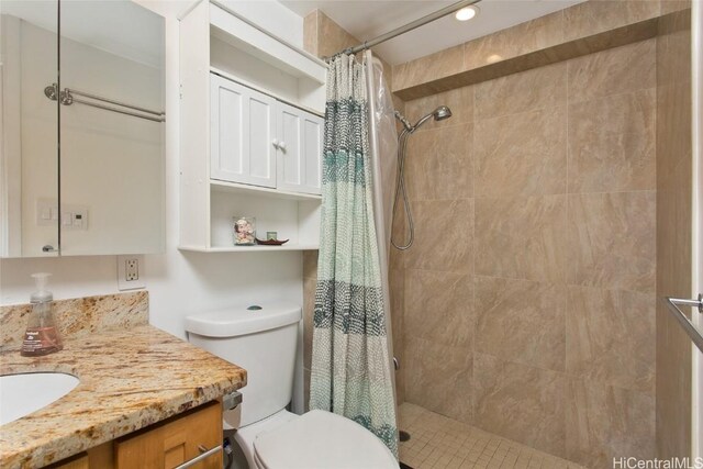 full bath featuring toilet, tiled shower, and vanity