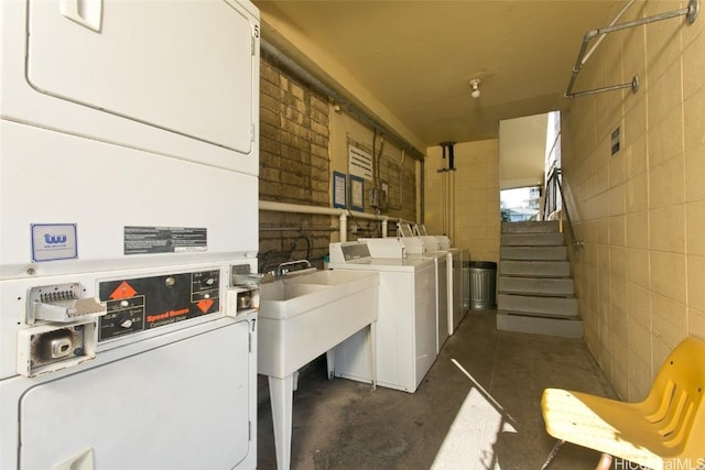 common laundry area with washing machine and dryer, tile walls, and stacked washer / drying machine